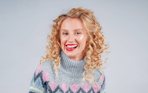 Attractive happy student woman with curly hair dressed in warm sweater - Foto, immagini