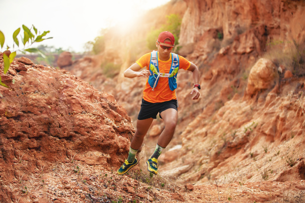 Ένας άνδρας δρομέας του Trail. και τα πόδια αθλητή φορώντας αθλητικά παπούτσια για trail running μέσα στα βουνά - Φωτογραφία, εικόνα