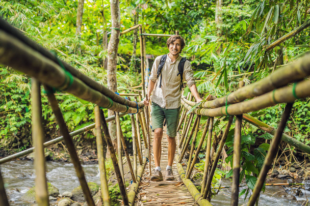Male traveler on the suspension bridge in Bali - Φωτογραφία, εικόνα