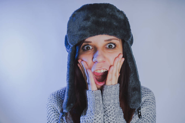 Emotional portrait of a girl, shooting in a photo Studio using a blue filter, Street style clothing hat and sweater - Photo, Image