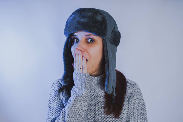 Emotional portrait of a girl, shooting in a photo Studio using a blue filter, Street style clothing hat and sweater - Foto, afbeelding