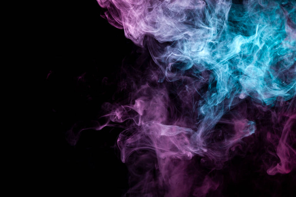 Colorful pink and blue smoke  on a black isolated background. Background from the smoke of vap - Fotografie, Obrázek
