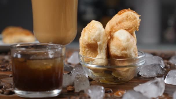 Guten Morgen. leckere Croissants auf Glasschüssel und Kaffee-Latte in durchsichtiger Tasse. Kaffeehauskonzept. hd - Filmmaterial, Video