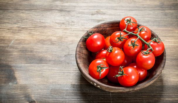 Ripe tomatoes in a bowl . On a wooden table. - Foto, Bild