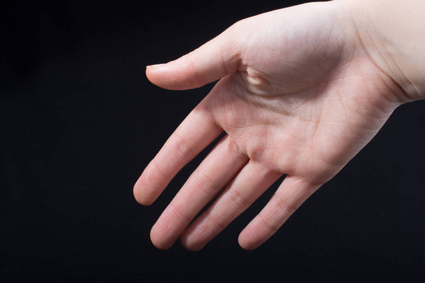 П'ять пальців дитини частково видно на чорному тлі
 - Фото, зображення
