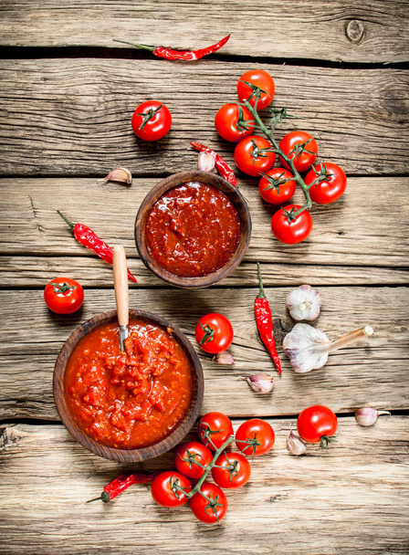 Tomato sauce with spices. On a wooden background. - Valokuva, kuva