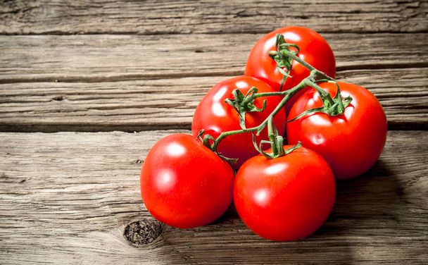Fresh ripe tomatoes. On a wooden background. - Fotografie, Obrázek
