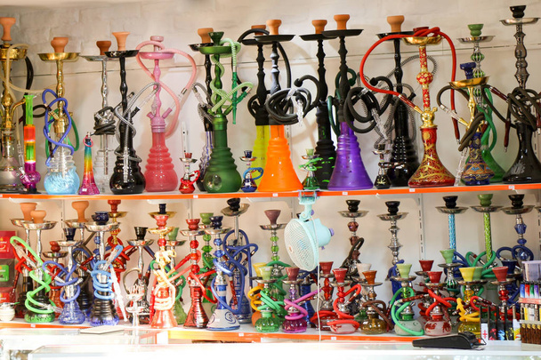 Gruppe orientalischer Wasserpfeifen in verschiedenen Farben auf einem Regal - Foto, Bild