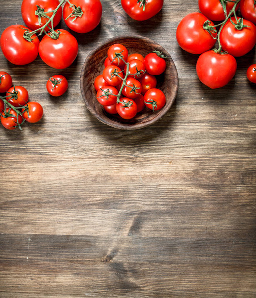 Ripe tomatoes in a bowl . On a wooden table. - Φωτογραφία, εικόνα