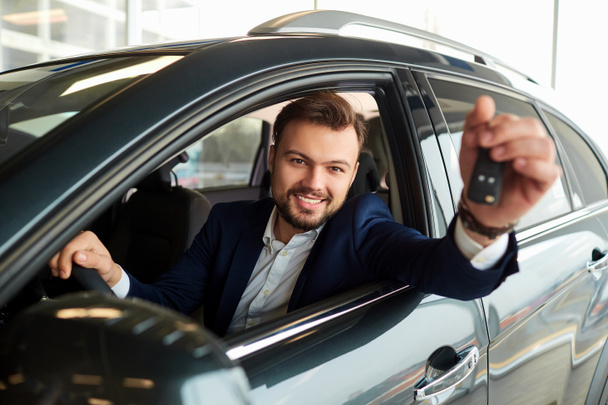Male driver smiling holds the keys to the car - Zdjęcie, obraz