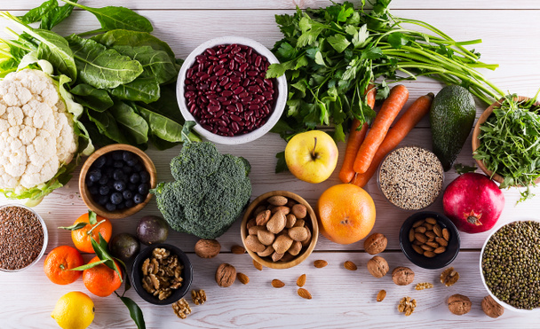 健康食品を食べてきれい: 果物、野菜、種子、スーパー フード、穀物、コピー スペース、上から見ると黒ウッドの背景の葉野菜. - 写真・画像
