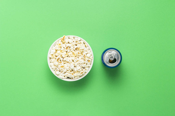 Ciotola con popcorn e una lattina di bevanda su sfondo verde. Il concetto di guardare film e programmi TV preferiti, competizioni sportive. Posa piatta, vista dall'alto
 - Foto, immagini