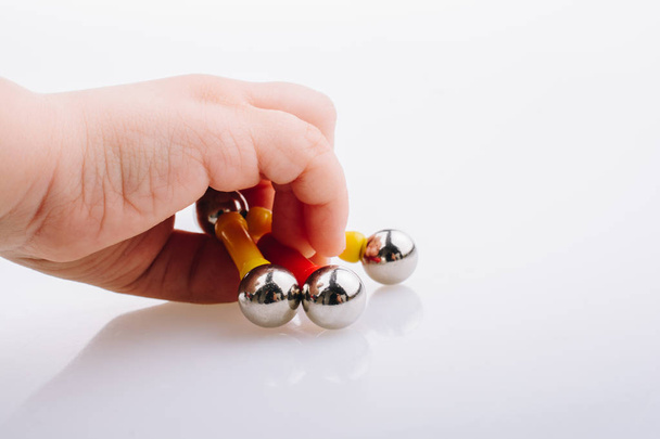 Ruční držení magnet hračky tyčinky a magnetické koule na bílém pozadí - Fotografie, Obrázek