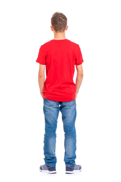 Full length portrait of young caucasian teen boy - rear view, isolated on white background. Funny teenager - back view. Handsome child with hands in pockets. - Φωτογραφία, εικόνα