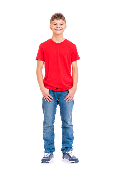Full length portrait of young caucasian teen boy, isolated on white background. Funny teenager looking at camera and smiling. Handsome child with hands in pockets. - Foto, Imagem