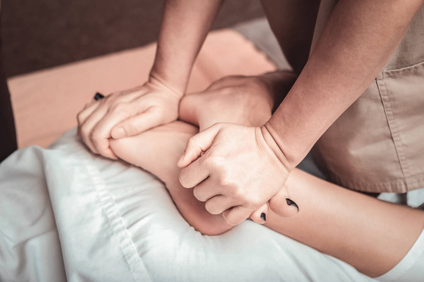 Top view of nice female feet being massaged - Foto, Imagen