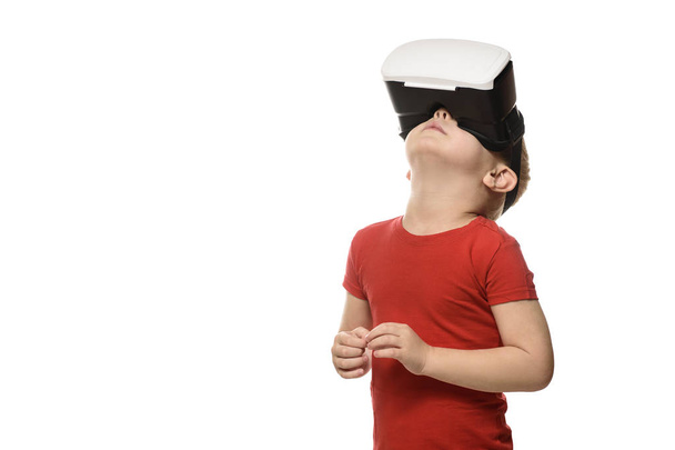 Маленький хлопчик у червоній сорочці відчуває віртуальну реальність, піднімаючи голову. Ізольовані на білому тлі. Технологія концепції
. - Фото, зображення
