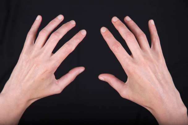 manos femeninas delgadas expresivas delgadas en varias poses sobre un fondo negro
 - Foto, imagen