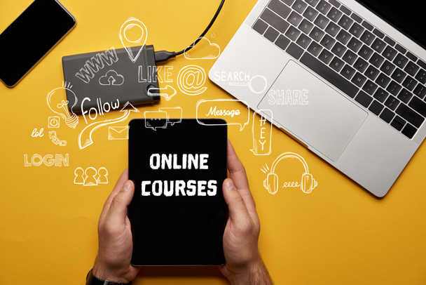 cropped view of man holding digital tablet with online courses illustration  - Photo, Image