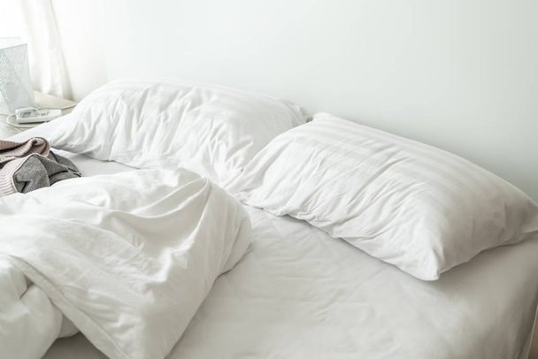 white pillow on bed and with wrinkle messy blanket in bedroom - Fotografie, Obrázek