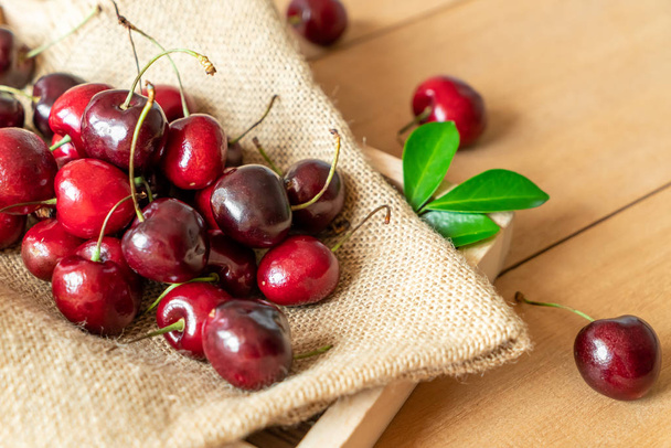 Fresh cherries in bowl  on wood background - Photo, Image