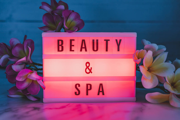 beauty and spa lightbox text surrounded by tropical frangipani monoi flowers - Photo, Image