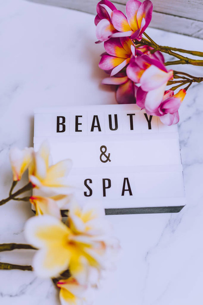 beauty and spa lightbox text surrounded by tropical frangipani monoi flowers - Fotoğraf, Görsel
