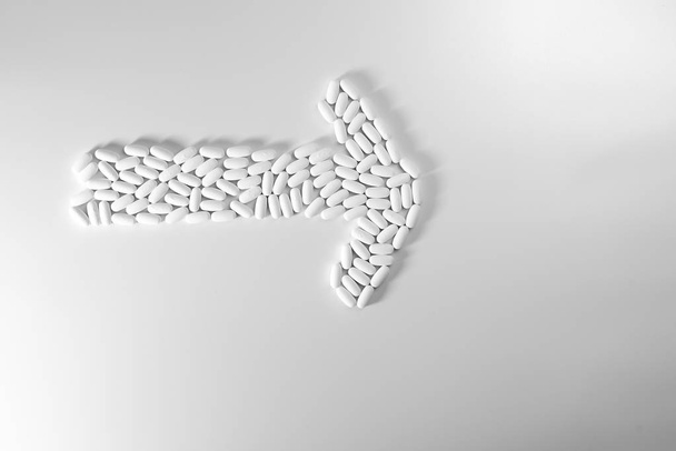 Suunta nuoli valmistettu pillereitä eristetty valkoisella pohjalla, lääketiede käsite
 - Valokuva, kuva