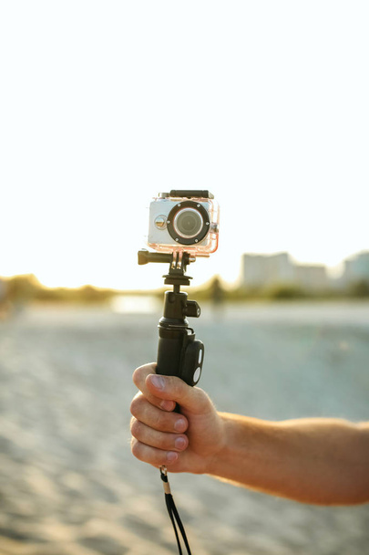 Young man filming video with action camera at the desert - Foto, imagen