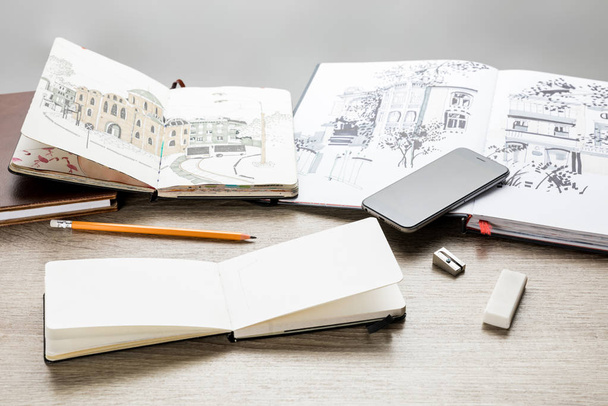 selective focus of drawing albums, drawing utensils and smartphone on wooden table - Фото, зображення