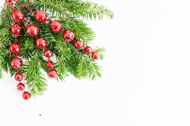 トップビューフラットは、明るい背景に赤いおもちゃ、弓とガラストナカイのコーナーフレームと自然なクリスマスツリーの枝を置きます。新年の装飾の概念。テキストスペース - 写真・画像
