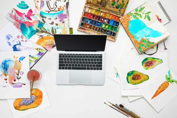 felülnézet laptop körülvett akvarelljei festékek rajzok - Fotó, kép