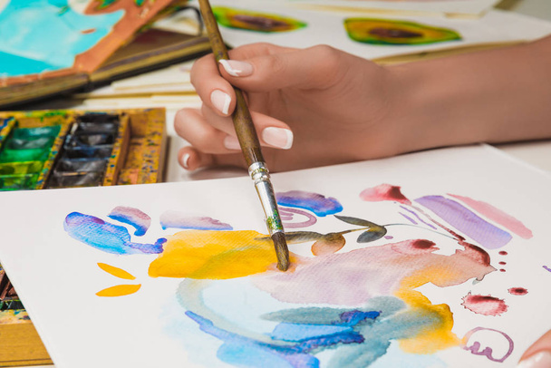 Selektivní fokus ženské ruky kresby na papíře s akvarel barvy a štětec - Fotografie, Obrázek
