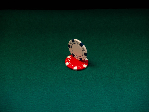 Una ficha de póquer en movimiento y otra se detuvo en una alfombra verde
 - Foto, imagen