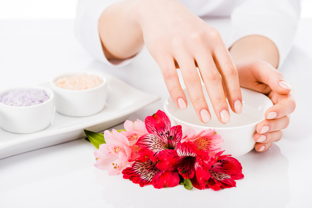 Partial view of woman with perfect manicure doing hand treatment - 写真・画像