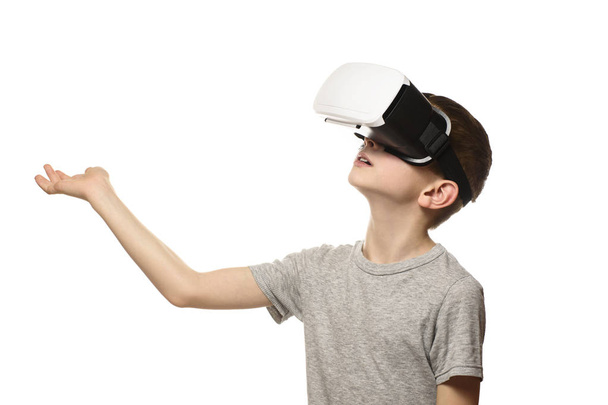 Poika kokee virtuaalitodellisuuden käsi ojennettuna hänen edessään. Eristää valkoisella taustalla. Teknologian käsite
. - Valokuva, kuva