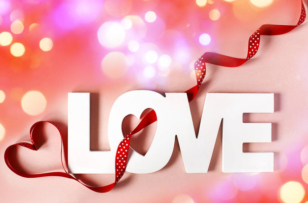 Word Love at pink background with bokeh lighting - Foto, Imagen