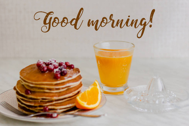 Stack of pancakes with cranberries and maple syrup and orange juice on marble background - Zdjęcie, obraz