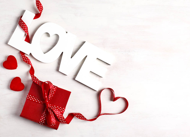 Word Love and red gift box at white background, copy space - Φωτογραφία, εικόνα