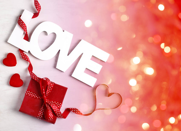 Word Love and red gift box at white background, copy space - Photo, Image