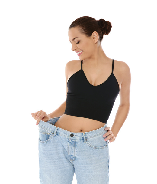 Slim woman in oversized jeans on white background. Weight loss - Valokuva, kuva