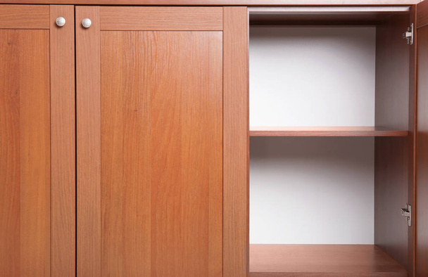 Open wooden wardrobe with empty shelves, closeup - 写真・画像