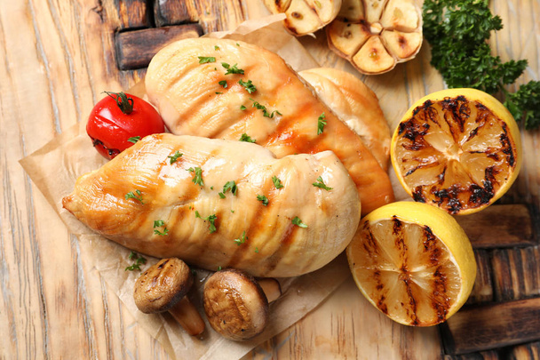 Grilled chicken breasts with garnish on wooden background, top view - Фото, зображення