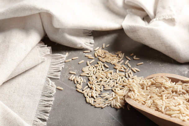 Brown rice and scoop on grey table, closeup view - Valokuva, kuva