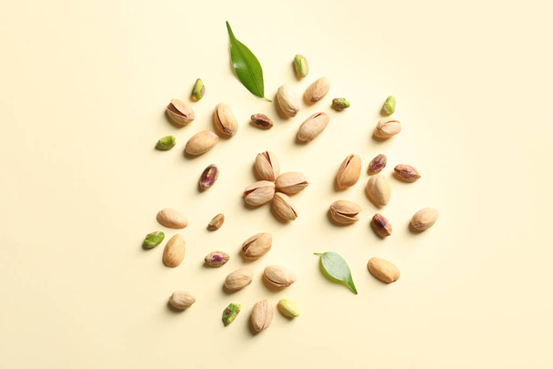 Composition with organic pistachio nuts on color background, flat lay - 写真・画像