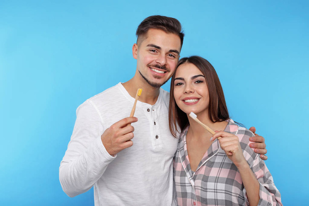 Happy couple brushing teeth on color background - Foto, afbeelding
