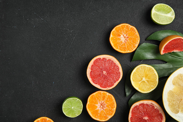 Different citrus fruits on black background, flat lay. Space for text - Fotoğraf, Görsel