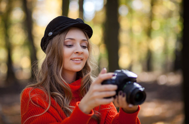 Young woman having fun with camera making photos at green park - Foto, imagen