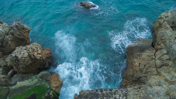 Kayalık bir plajda dalgalar kırılan ve köpüren üst görünüm deniz. Cote d'Azur üzerinde büyük taşlar ile Sahil - Fotoğraf, Görsel