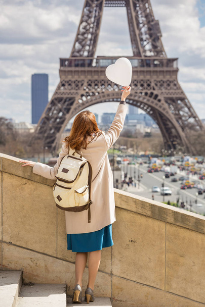 trip across Europe. girl with a balloon in the shape of a hearton the background of the Eiffel Tower in Paris. France - 写真・画像